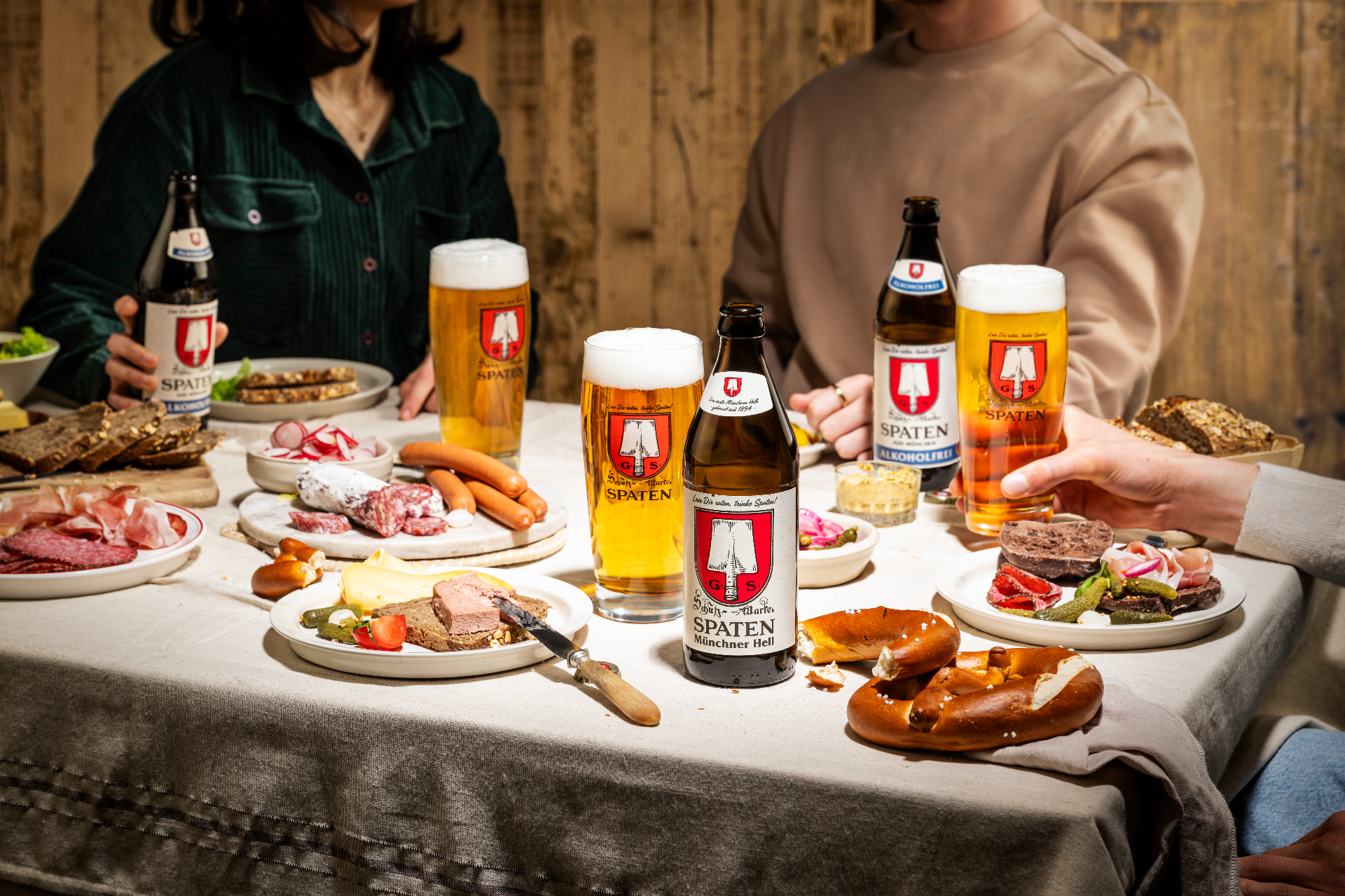 Set table with Spaten beer, pretzels, sausage and snacks in a festival-tent atmosphere